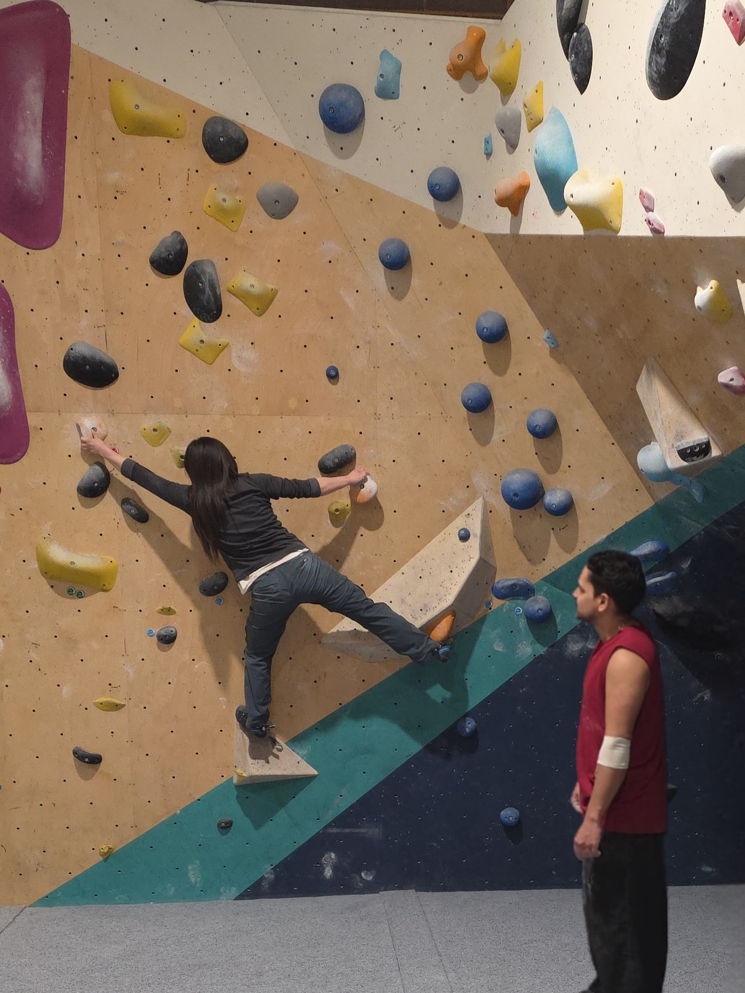 Kamran coaching a climber on a bouldering wall
